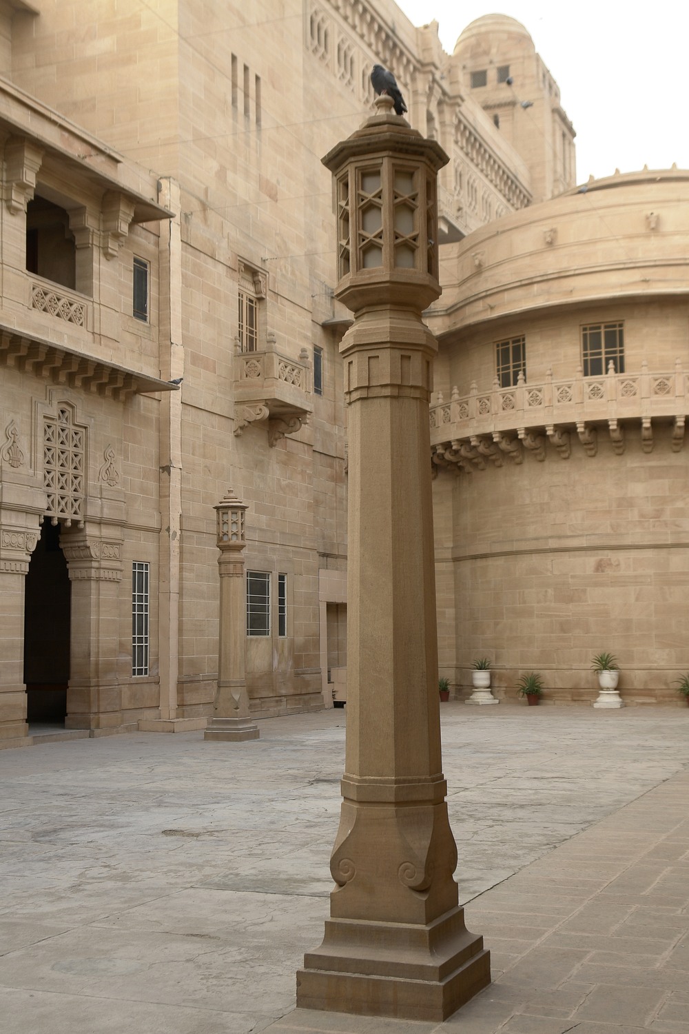 Carved sandstone lamp columns and balconies in a courtyard of Umaid Bhawan Palace.